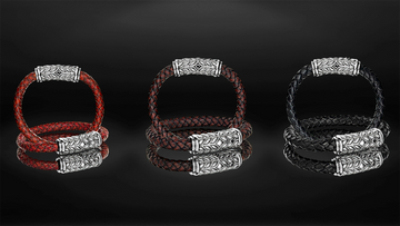 Three braided leather bracelets with metal clasps on a reflective black surface.