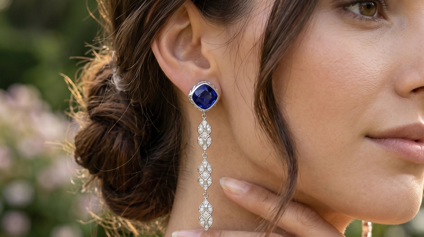 Persian Shield chandelier earrings in sterling silver with blue sapphire and diamond-set leaf drops, worn on ear in natural light close-upslider_item_UFaDBy