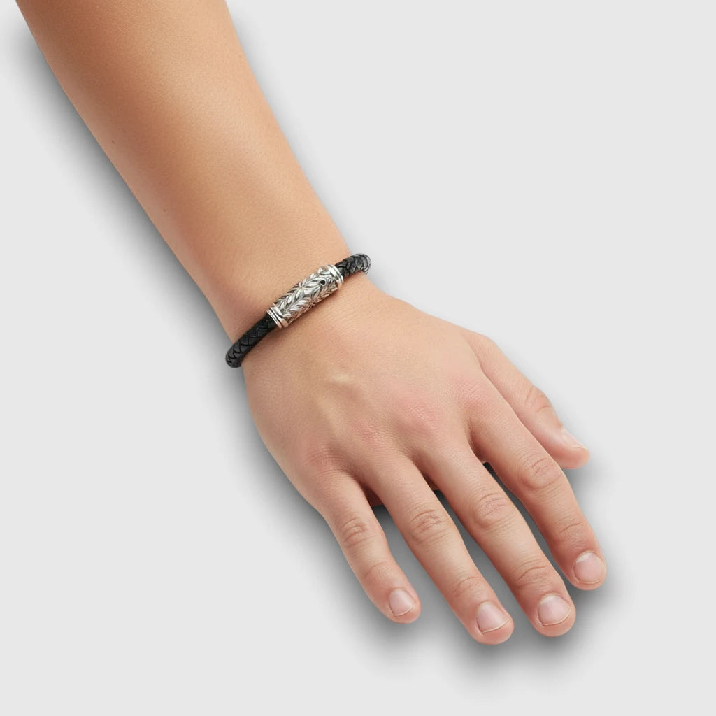 Men’s black leather bracelet with black diamond & sterling silver clasp, shown worn on wrist against neutral background