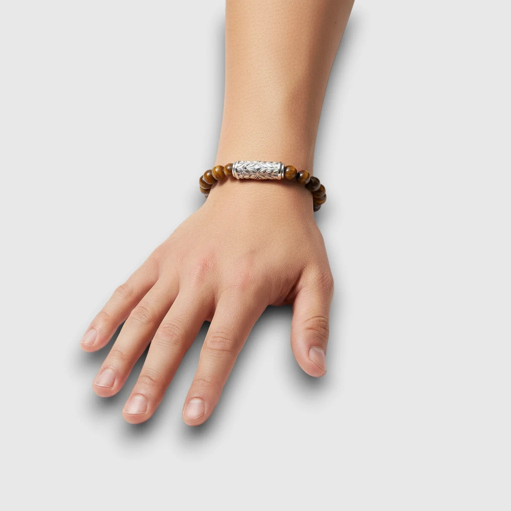 Yellow tiger eye beaded bracelet with engraved sterling silver clasp shown on wrist, natural scale and fit.