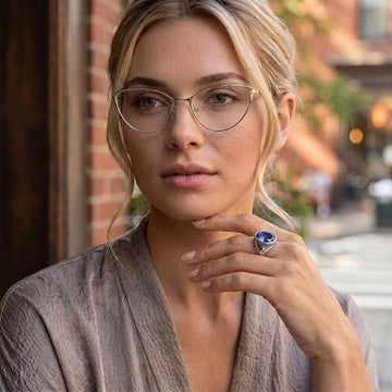 Woman wearing sterling silver ring with blue sapphire in soft natural light editorial portrait