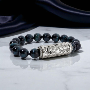 Black beaded bracelet with a silver clasp on a marble surface