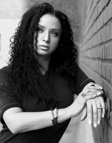 Black and white portrait of Daneila Léon, founder of the brand, wearing signature handcrafted silver jewelry.