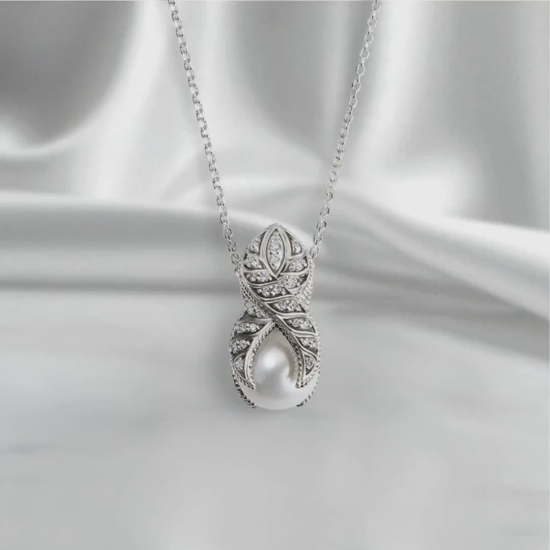 Sterling silver pendant necklace with freshwater pearl, natural blue sapphire, and lab-grown diamond accents, displayed on a satin backdrop with soft studio lighting and slow movement highlighting its polished finish