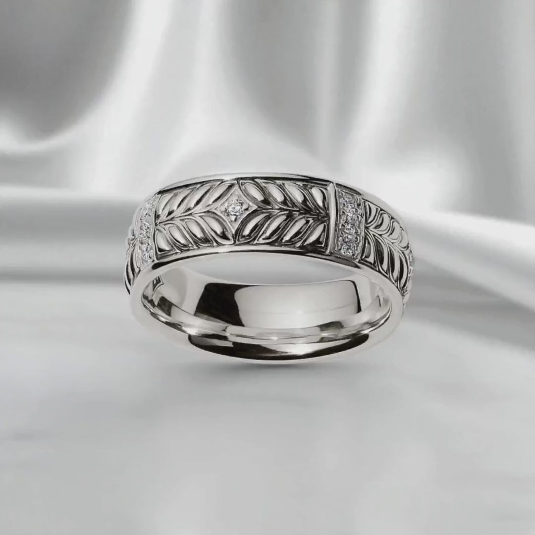 Sterling silver Persian Shield band with sculpted leaf motif and diamond accents, shown on a soft satin backdrop to highlight detail and craftsmanship